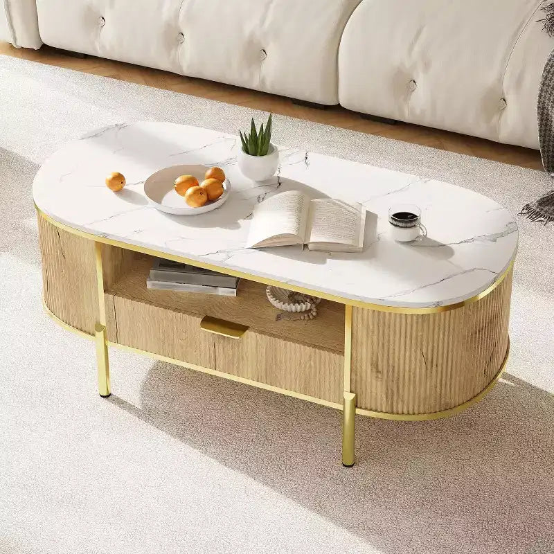 Tavolino da caffè ovale scanalato da 48" con piano in finto marmo, gambe dorate e cassetto portaoggetti nascosto